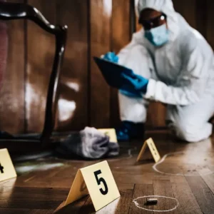 A person in white suit and blue gloves investigating a room.