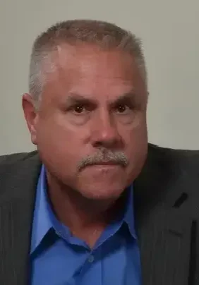A man with a beard and mustache wearing a suit.