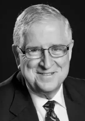 Elderly professional wearing glasses and suit